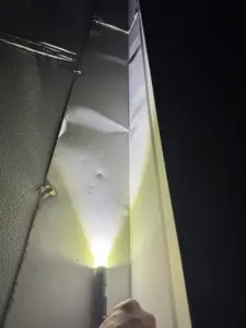 Hail Damage to gutters shown with flashliight