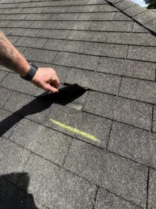 Pre-inspection of damaged asphalt shingles — Integrity Roof Services team documenting wind-lifted tabs and UV wear.