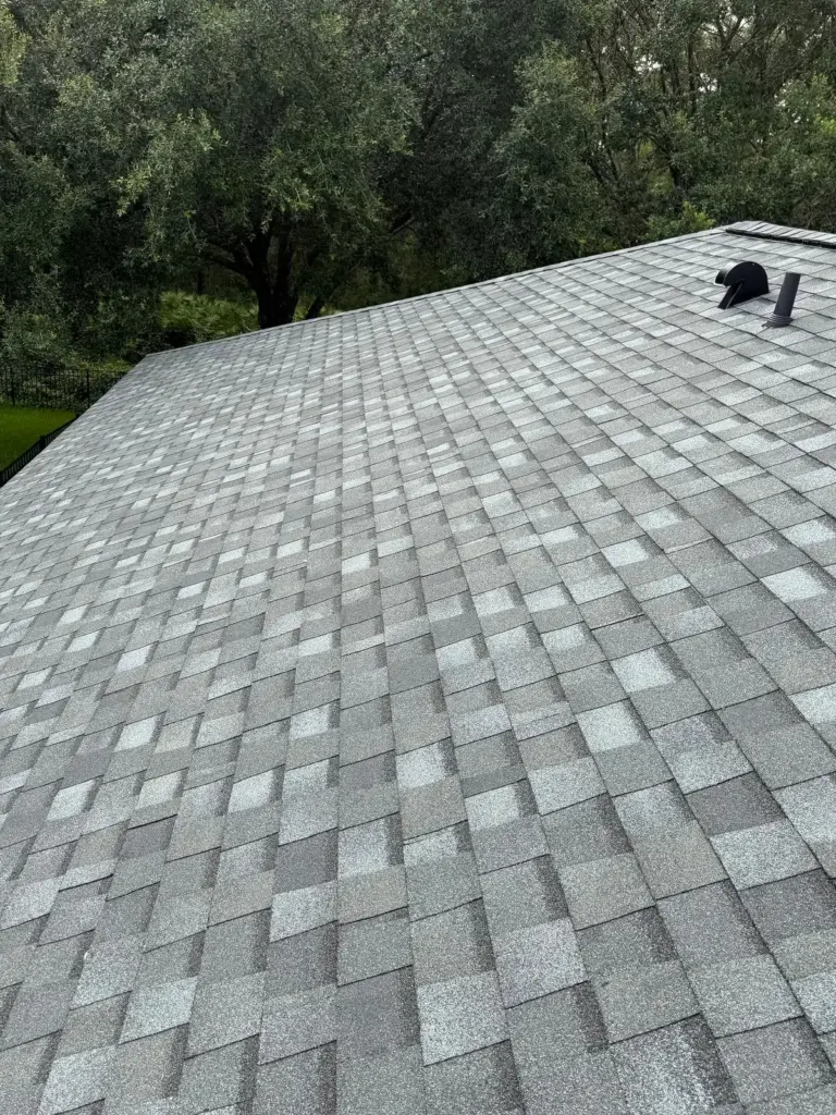 After roof photo of front elevation showing new Atlas Pinnacle Pristine Coastal Granite shingles installed by Integrity Roof Services in Orlando, FL.