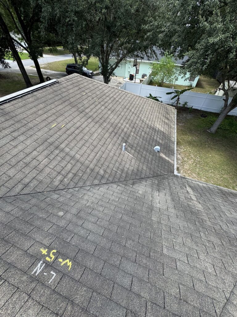 Roofing Projects FL 3 “Close-up of storm-damaged shingles in Longwood, Florida before roof replacement by Integrity Roof Services.”