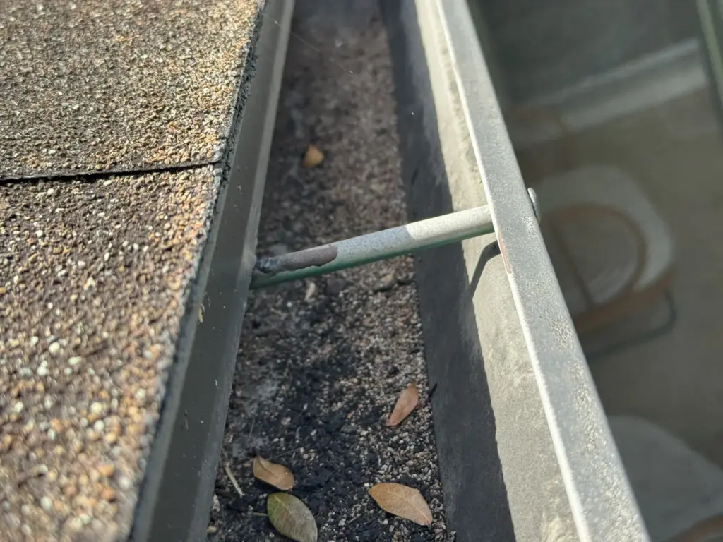 torm-damaged shingles in Winter Park, FL showing lifting and granule loss before roof replacement by Integrity Roof Services.