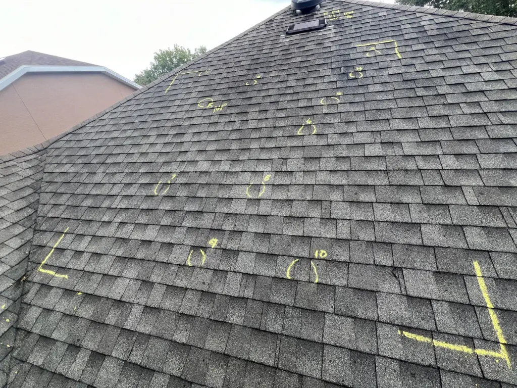 Severe Hail-Damaged Roof Replacement in DeLand, FL 5 Multiple hail impact points across aging asphalt roof confirming full replacement needed in DeLand, Florida.