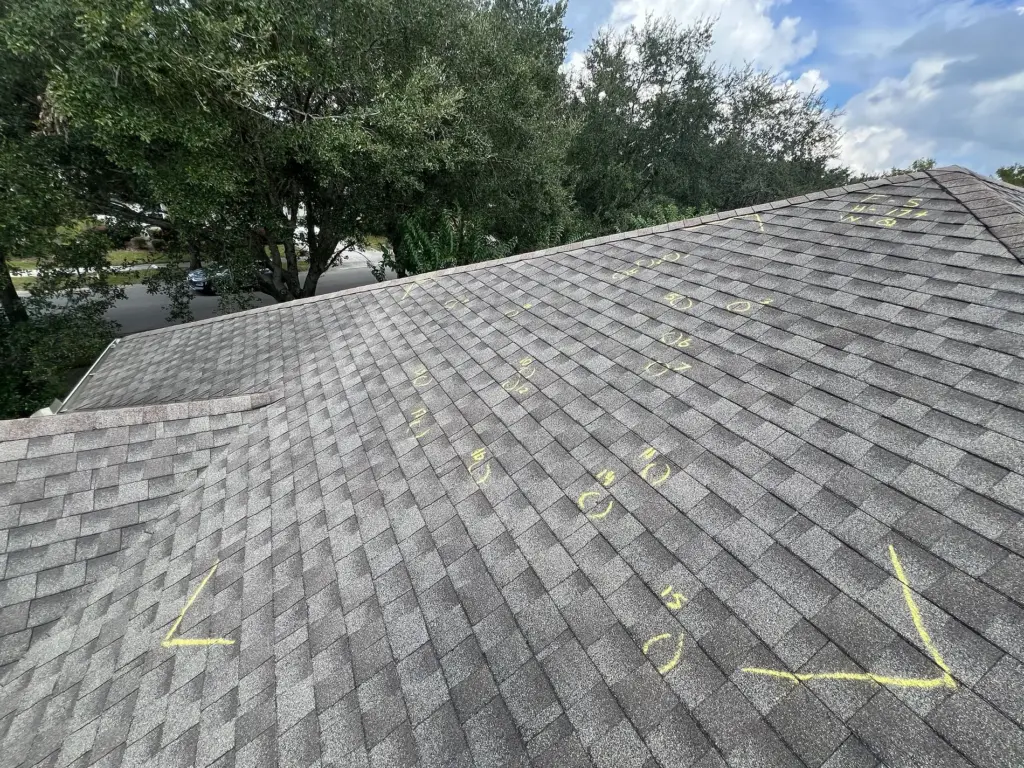 Severe Hail-Damaged Roof Replacement in DeLand, FL 3 Severe hail damage visible on asphalt shingles with heavy bruising and granule loss before roof replacement in DeLand, FL.