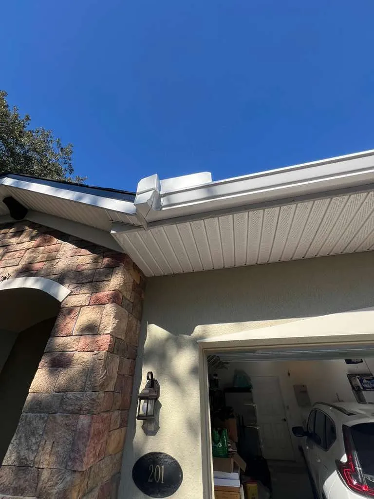 Severe Hail-Damaged Roof Replacement in DeLand, FL 6 Clean roofline showing new shingles, white soffit, and newly installed gutters after major hail damage repair in DeLand.