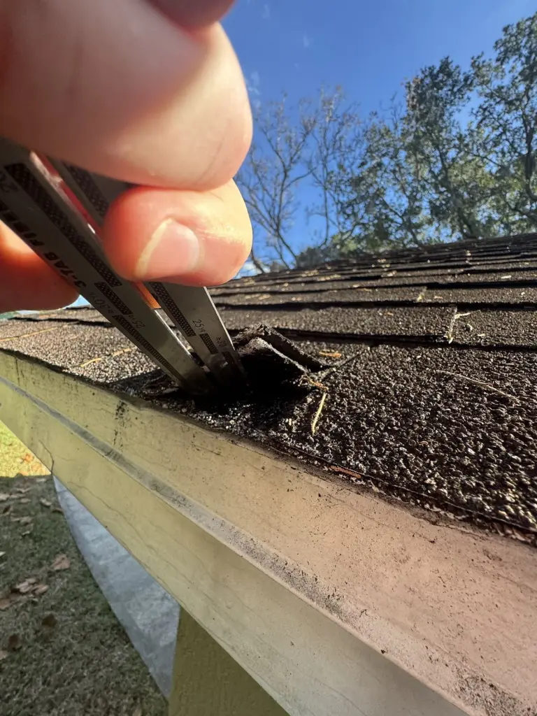 Roofing Projects FL 5 Close-up inspection of asphalt shingle edge condition before roof replacement in Port Orange, Florida