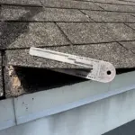 Shingle thickness verification — confirming wear and aging on existing asphalt shingles prior to installing Atlas Pinnacle Pristine Coastal Granite. Shingle thickness verification — confirming wear and aging on existing asphalt shingles prior to installing Atlas Pinnacle Pristine Coastal Granite.