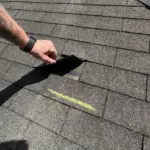 Pre-inspection of damaged asphalt shingles — Integrity Roof Services team documenting wind-lifted tabs and UV wear. Pre-inspection of damaged asphalt shingles — Integrity Roof Services team documenting wind-lifted tabs and UV wear.