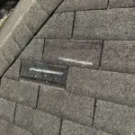 Missing and lifted shingles identified during inspection — wind damage and granule loss documented for insurance and replacement approval. Missing and lifted shingles identified during inspection — wind damage and granule loss documented for insurance and replacement approval.