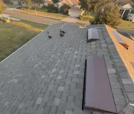 “Completed roof system with Weathered Wood shingles and new ridge components captured at sunset after Mount Dora storm-damage restoration. Full ridge and slope view at sunset