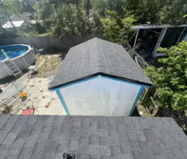 Finished roof replacement showing the new Atlas Black Shadow shingles over the rear section of the home. Completed Atlas Roofing System Over Patio Area in Daytona Beach FL